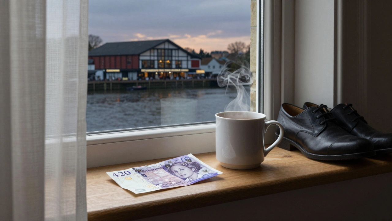 A steaming mug and folded cash rest on a windowsill overlooking Stratford’s cinema and river at dusk.