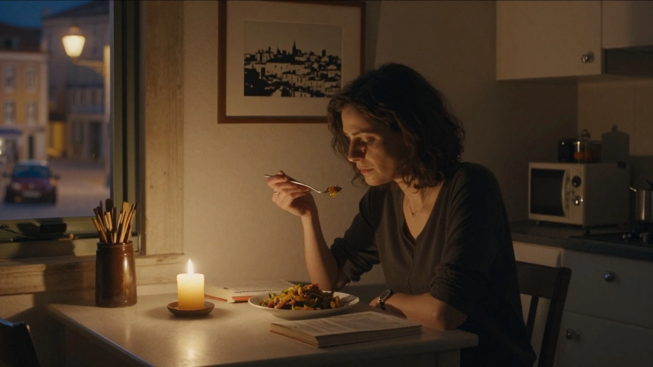A woman eating dinner alone at night, a book open beside her, with a Lisbon skyline print on the wall.
