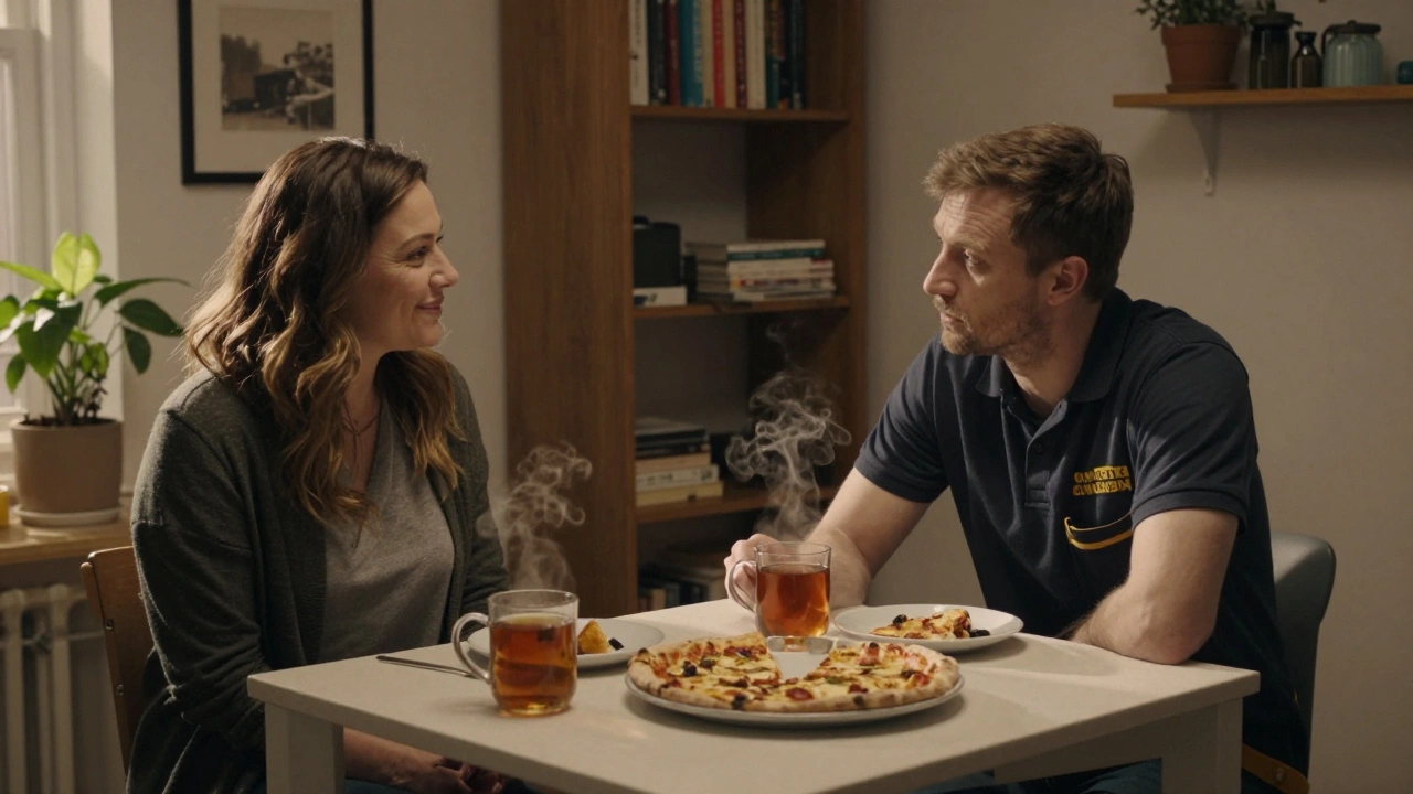 Two people share a simple home-cooked meal in a modest flat, talking softly under warm lamplight.